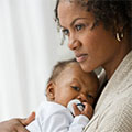 mom holding baby with pacifier