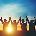 Silhouette of team raising their hands over their heads