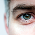 A close-up view of an adult man’s face and eye