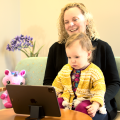 Toddler watching clips via the SenseToKnow app while sitting in caregiver's lap