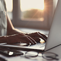 Hands typing at a computer